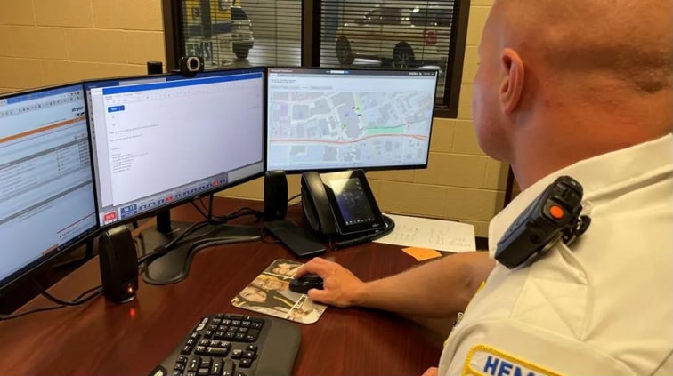 An EMS officer at a desk entering protocols on a computer